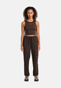 Brun cropped tank top med "HALO" logo, parret med højtaljede brune bukser, der har en tekstureret stof og elastisk talje.