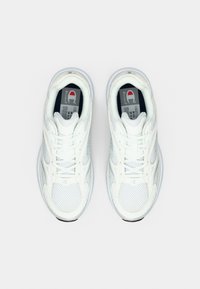 Ζευγάρι λευκά αθλητικά παπούτσια Champion από δίχτυ και δέρμα με κορδόνια, που φαίνονται από πάνω, σε μονόχρωμο ανοιχτό γκρι φόντο.