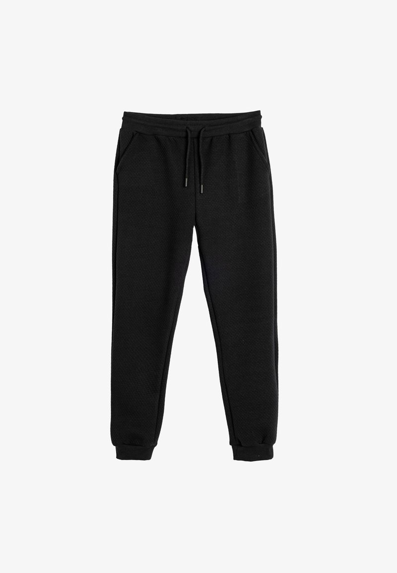 Black sweatpants with a textured fabric, elastic waistband, drawstring closure, and side pockets. Tapered cuffs at the ankles.