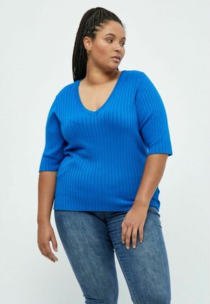 Blue ribbed knit top with a V-neck and short sleeves, featuring a relaxed fit and a textured finish. Paired with blue jeans.