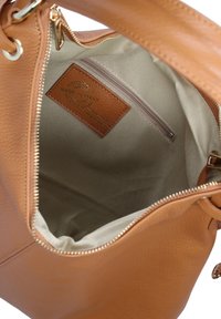 Borsa a mano in pelle marrone con interno in tessuto beige, tasca interna con zip e etichetta in pelle "Made in Italy" cucita all'interno.