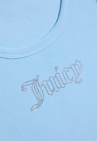 Tissu côtelé bleu clair avec un gros plan sur un col rond et le mot « Twice » écrit en strass argentés.