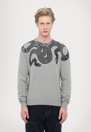 Maglione grigio con maniche lunghe, caratterizzato da un design di serpente nero sulle spalle. Il materiale appare texture con orlo e polsini a coste.