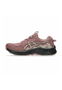 Zapatilla de trail running en rosa polvoriento con logotipo beige estampado, media suela negra y suela exterior beige clara, vista de lado.