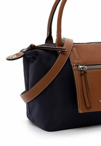 Borsa in pelle e tessuto caratterizzata da un corpo blu navy, dettagli in pelle marrone, tracolla regolabile e tasca con zip.