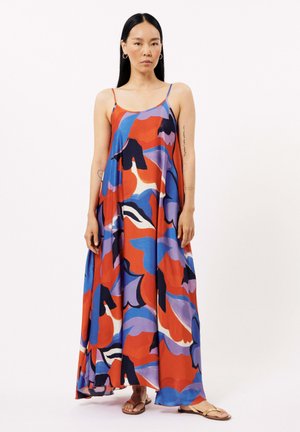 Robe maxi avec un motif floral multicolore vibrant, dotée de bretelles spaghetti et d'une silhouette fluide, fabriquée en tissu léger.