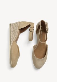 Zapatos espadrilles de ante beige con cuña de yute trenzado, parte trasera abierta y correa en el tobillo. Textura suave y diseño de punta redonda.