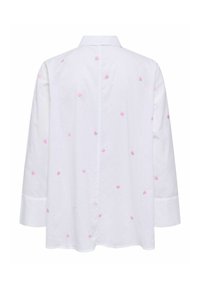 Chemise blanche à manches longues, ornée de cœurs brodés roses, col classique et coupe ample. Le tissu semble lisse et léger.