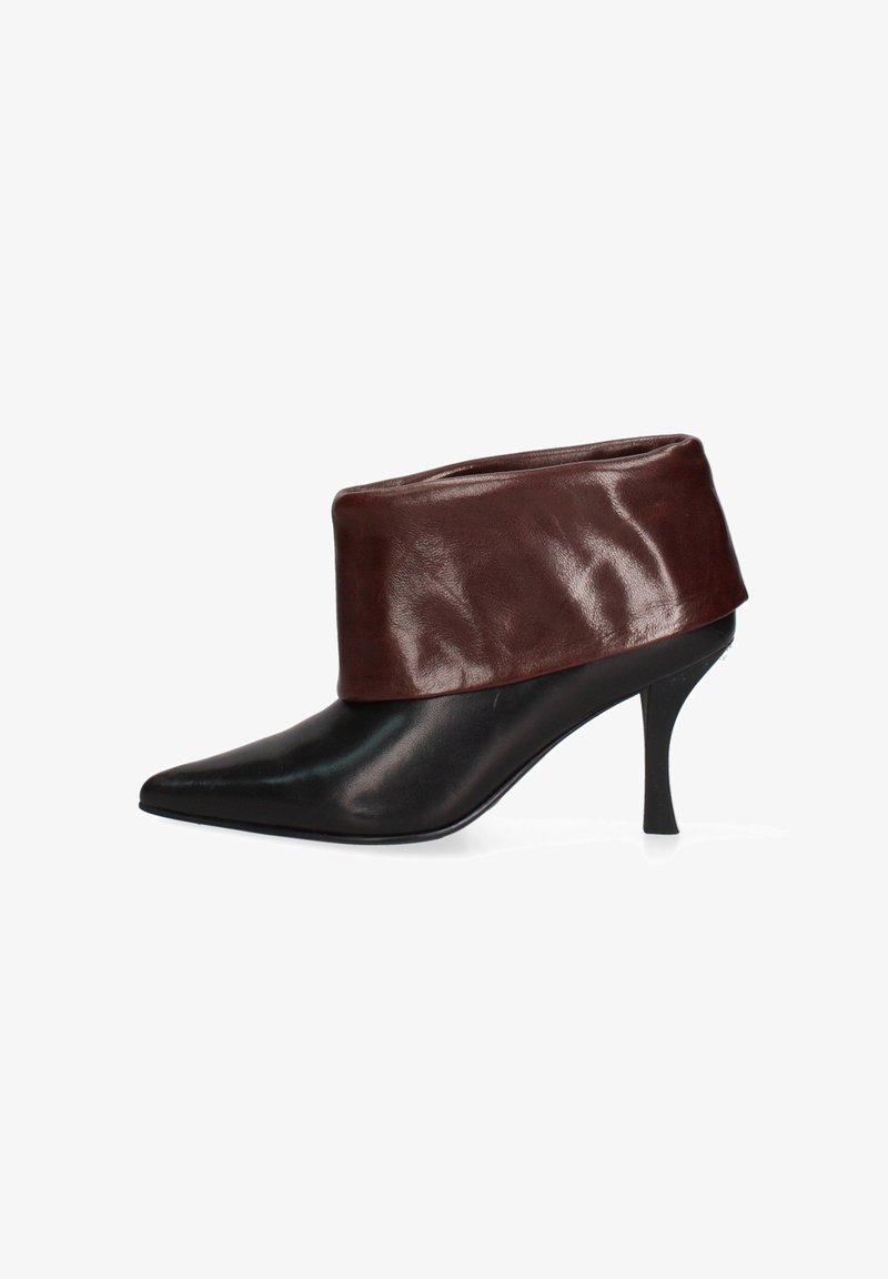 Scarpe nere in pelle con punta affusolata e una polsino in pelle marrone alla caviglia, caratterizzate da un tacco sottile per un design elegante e moderno.