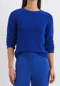 Royal blue, gebreide trui met textuur, ronde halslijn en lange mouwen. Gecombineerd met bijpassende blauwe aansluitende broek van een gladde stof.