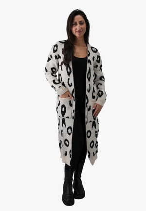 Cardigan lungo aperto in crema con stampa leopardata astratta nera. Presenta tasche e polsini a costine, realizzato in un materiale a maglia testurizzato.