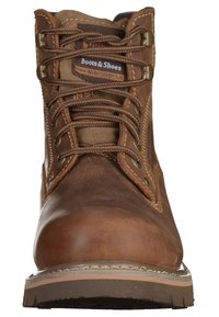 Bota de cuero marrón con ojales de metal y cordones, cuello acolchado, acentos de costura y una suela de caucho duradera.