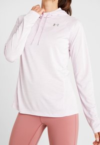 Helle rosa Longsleeve-Hoodie aus weichem Stoff mit Kapuze und Kordelzug sowie kleinem Logo auf der Brust; glatte Textur und lockere Passform.