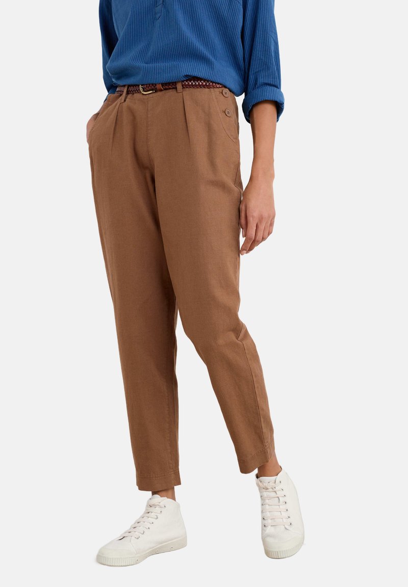 Bruna byxor med skräddarsydd passform, med sidfickor och knappramar. Kombinerat med vita sneakers och en blå ribbad topp.