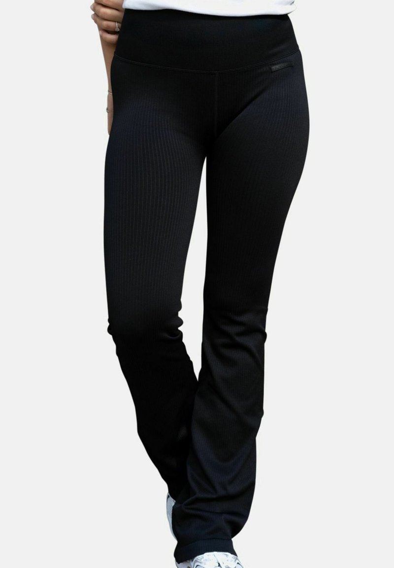 Svarta ribbstickade leggings av elastiskt material med bred midjeresår, åtsittande design och utan synliga detaljer eller mönster.