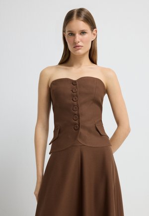 Haut sans bretelles marron en tissu texturé, avec six boutons à l'avant et des poches latérales, un corsage ajusté et un bas évasé.