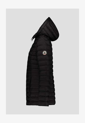 Chaqueta acolchada negra con capucha, que presenta un diseño acolchado, textura suave y un parche con logo circular en la manga izquierda.