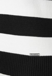 Knit sweater featuring horizontal black and white stripes, ribbed black hem, and a small silver brand tag labeled "MORE & MORE."