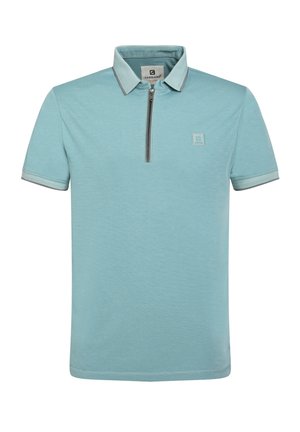 Polo de color azul claro con un cuello con cremallera, mangas cortas y un detalle de logo en el pecho. Presenta acentos de contraste en el cuello y las mangas.