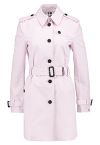 Jasnoróżowy płaszcz trenchowy wykonany z gładkiego materiału, z podwójnym zapięciem, czarnymi guzikami, paskiem w talii oraz epoletami na ramionach.