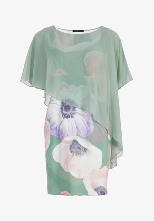 Blød grøn blomsterkjole med store hvide og lilla blomster, der har et gennemsigtigt asymmetrisk overlay og korte, flagrende ærmer.