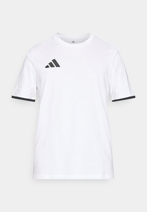 Biała bawełniana koszulka z krótkim rękawem, z czarnym logo Adidas w górnej lewej części i czarnym wykończeniem na rękawach.