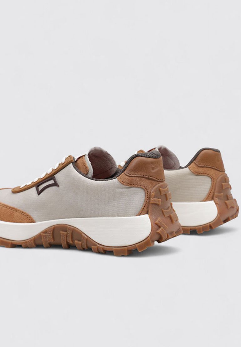 Snörskor med en beige textilovandel och bruna mockaaccenter samt en gummiyttersula, som inkluderar strukturerade grepp för bättre fäste.