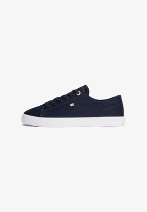 Donkerblauwe laag uitgesneden sneaker met witte zool, stoffen bovenwerk, veterluiting en een klein rechthoekig merklogo aan de zijkant.