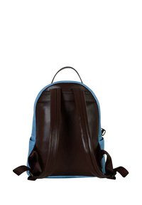 Mochila de tejido azul con acentos de cuero marrón. Cuenta con correas de hombro acolchadas y una asa en la parte superior para facilitar el transporte.