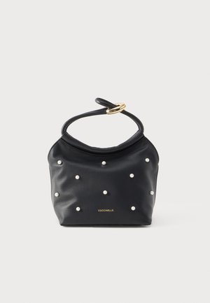 Borsa a tracolla in pelle nera con piccoli borchietti a forma di perla, manico pieghevole fissato da un anello dorato e logo "Coccinelle" in oro sul davanti.