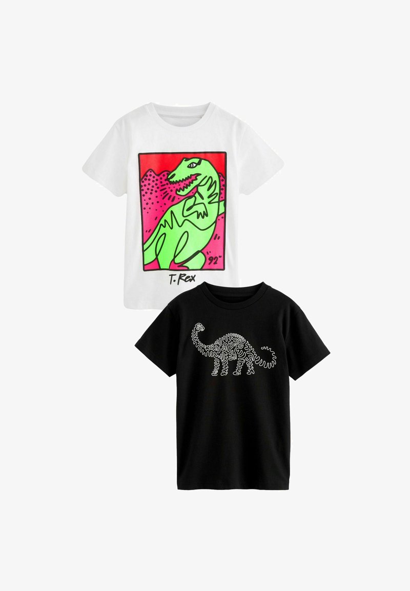 Dwie koszulki dziecięce: jedna biała z kolorową grafiką T-Rexa, druga czarna z konturowym rysunkiem dinozaura w białym kolorze. Obie są z krótkim rękawem.