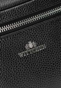 Černá kožená taška s texturovaným povrchem, stříbrnými kovovými doplňky, zipem a vyraženým logem "WITTCHEN" s korunkou a lvem.