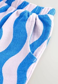 Baumwollkurzschlüsse mit einem wellenförmigen blau-weißen Muster, elastischem Bund und sichtbaren Nahtdetails.
