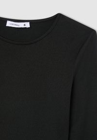 Czarna koszulka z okrągłym dekoltem, uszyta z miękkiego, gładkiego materiału. Posiada minimalne szwy oraz metkę z napisem "TERRANOVA" w rozmiarze małym.