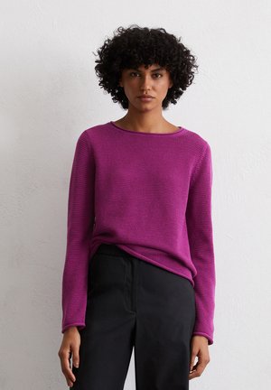 Magenta knit sweater with a crew neckline, long sleeves, textured fabric, and a relaxed fit, paired with black trousers.