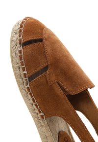 Espadrille en suède marron avec design découpé, semelle en jute et accents cousus. Dispose d'un intérieur doux et d'une surface texturée.
