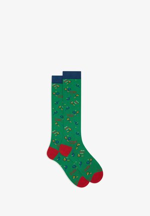 Green socks with red accents, featuring a playful pattern of tennis rackets and balls, made from a soft fabric.