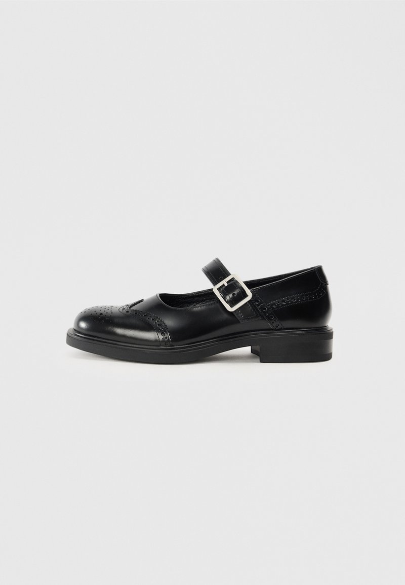 Chaussure Mary Jane en cuir noir avec un petit talon bloc, bout rond, détails de brogue décoratifs et une sangle réglable avec une boucle en métal.