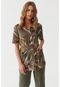 Camicia button-up verde oliva con stampa floreale, maniche corte, vita cinturata e due tasche frontali. Tessuto morbido e leggero.