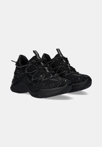 Zapatillas negras con un upper texturizado y acentos brillantes, diseño con cordones, cuello acolchado y suela gruesa para mayor soporte.