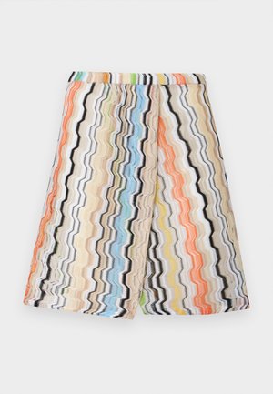 Dzianinowe szorty do kolan z wielokolorowymi paskami w zygzaki w kolorach pomarańczowym, niebieskim, zielonym, żółtym, czarnym i beżowym na białym tle.