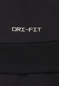 Tessuto nero con texture a coste con la scritta "DRI-FIT" ricamata in bianco. Il design mette in risalto le capacità di assorbimento dell'umidità.