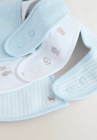 Heledsinine kangast söötja, millel on karu mustrid ja nööbipaneel; sisaldab erinevaid siledat ja triibulist tekstuuri.