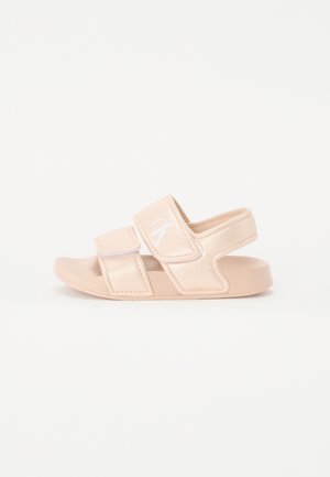 Lichtroze sandalen met twee verstelbare klittenbandsluitingen, een gestructureerd bovenmateriaal, een platte zool en een klein logo-detail aan de zijkant.