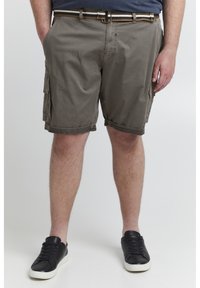 Khaki cargo shorts med lav talje, med sidelommer, opsmøgede kant og et mønstrede bælte. Båret med sorte sneakers.