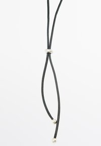 Collana in pelle nera con due fili, caratterizzata da un anello in metallo argentato e due perline argentate alle estremità. Texture liscia, design minimalista.