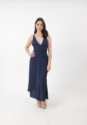 Abito lungo blu navy con scollatura a V profonda e spalline sottili, realizzato in tessuto leggero, caratterizzato da un corpino aderente e gonna fluente.