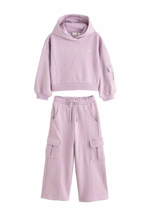 Felpa corta lilla con logo frontale e maniche lunghe, abbinata a pantaloni cargo a gamba larga coordinati, con tasche frontali e vita regolabile.