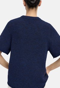 Granatowy, dziany sweter z krótkim rękawem i okrągłym dekoltem. Miękka tekstura z luźnym krojem i subtelnym melanżowym wzorem.