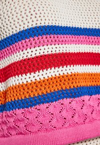 Stickad tyg med horisontella ränder i röd, rosa, orange, blå och vit. Texturen är öppen väv med en dekorativ, texturerad rosa kant.